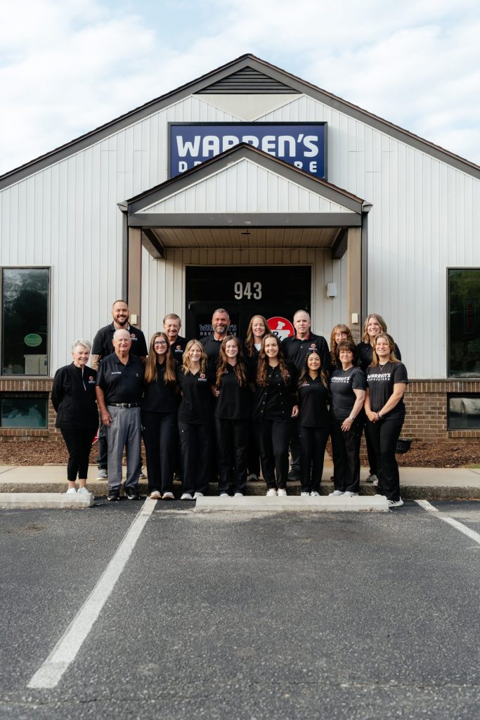 Warren's Drug Store pharmacy team in uniform in front of pharmacy door