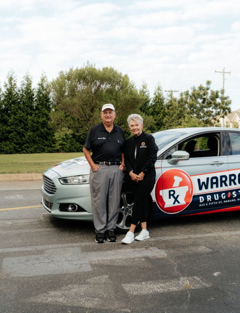 Older woman and man in front of Warren's Drug Store Delivery Car