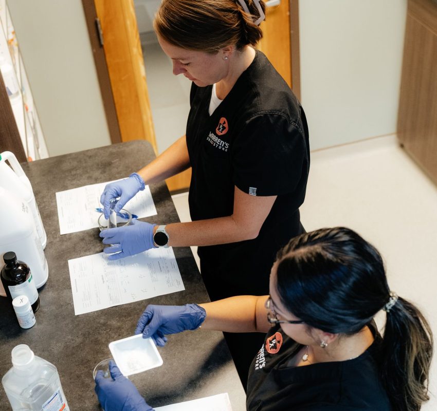 Warren's drug store compounding staff from above preparing prescription