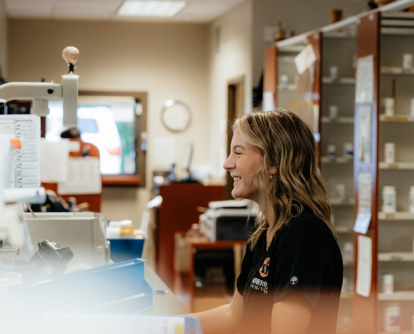 Pharmacy employee at Warren's Drug Store counter