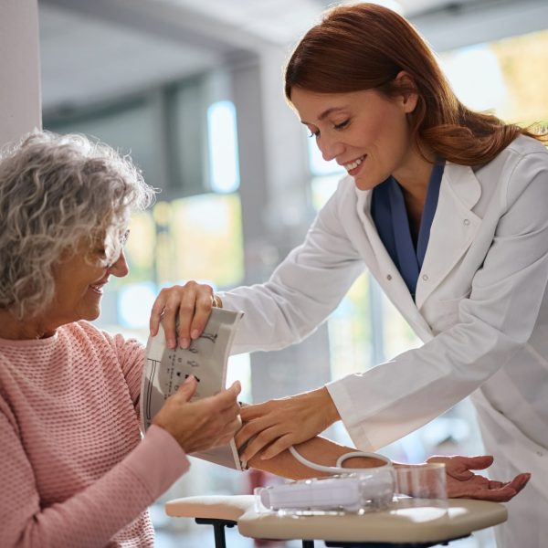 Pharmacist checks woman's blood pressure during health screening