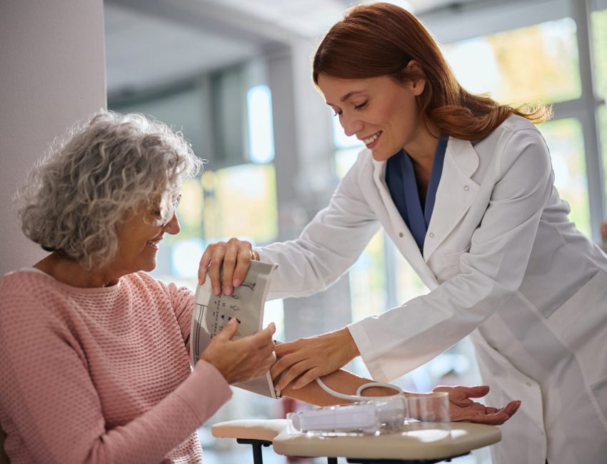 Pharmacist checks woman's blood pressure during health screening