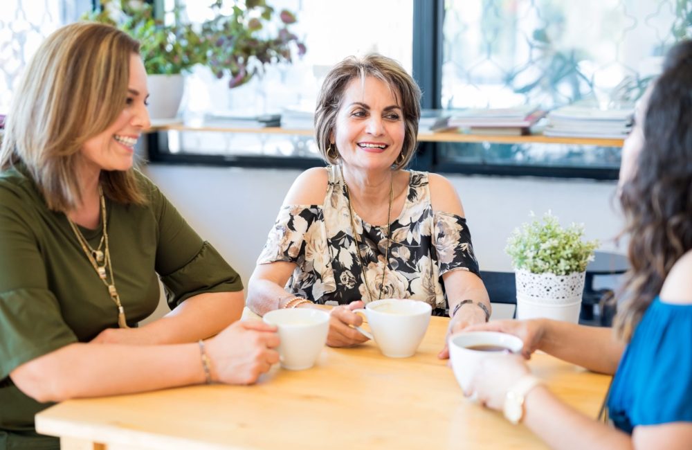 Three middle age women talk about hormone replacement at table