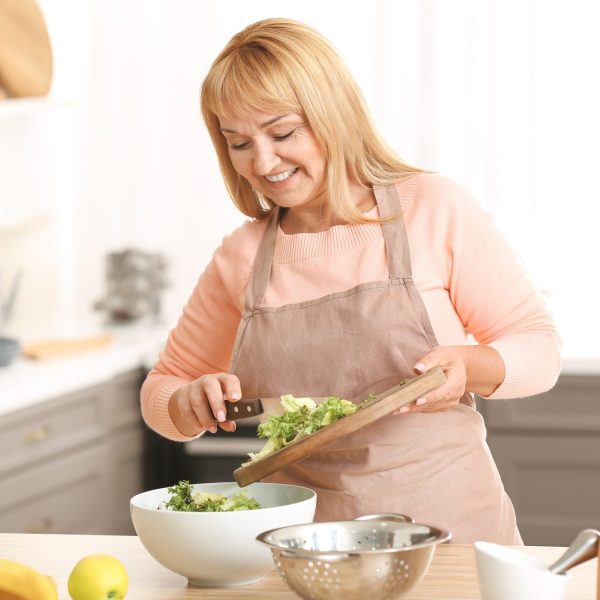 Woman cuts veggies to get the most out of fiber for weight loss
