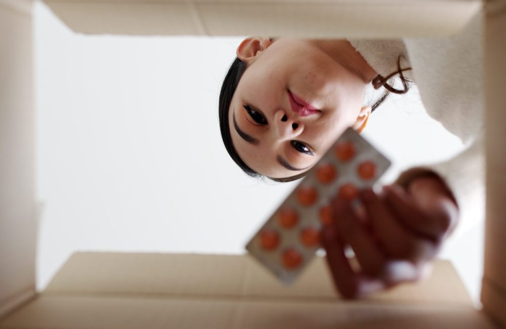 Woman taking medicine out of a package