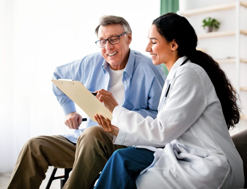 Older man talks with pharmacist about Medicare open enrollment