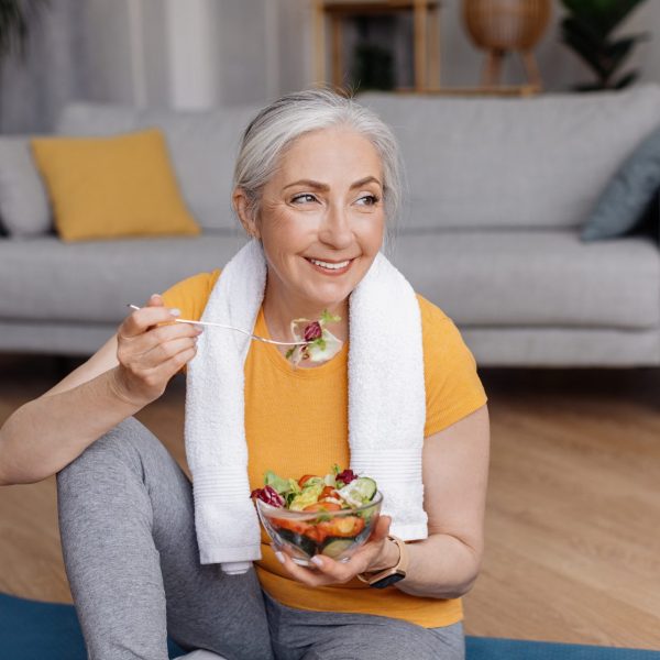 Woman eating salad to replace nutrients