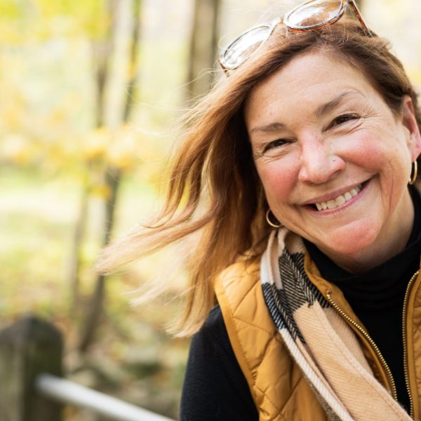 Middle aged woman smiles outdoors near Mebane