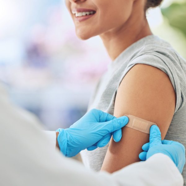 Pharmacist puts band aid on woman's arm after vaccine