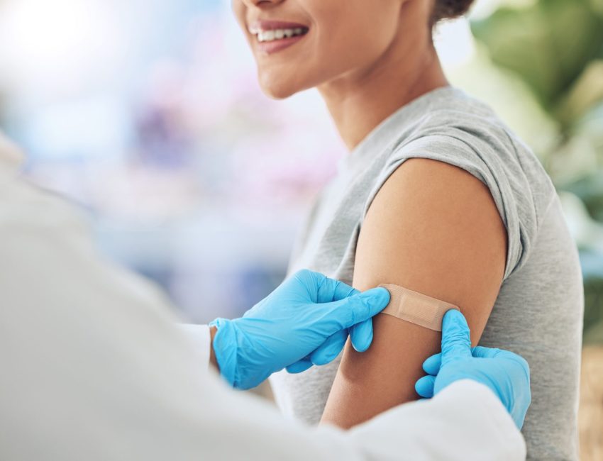 Pharmacist puts band aid on woman's arm after vaccine