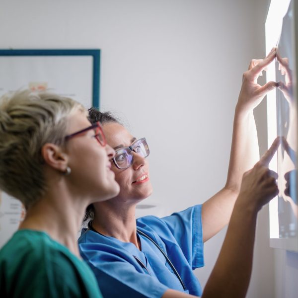 A woman and her doctor review her x-ray for signs of osteoporosis