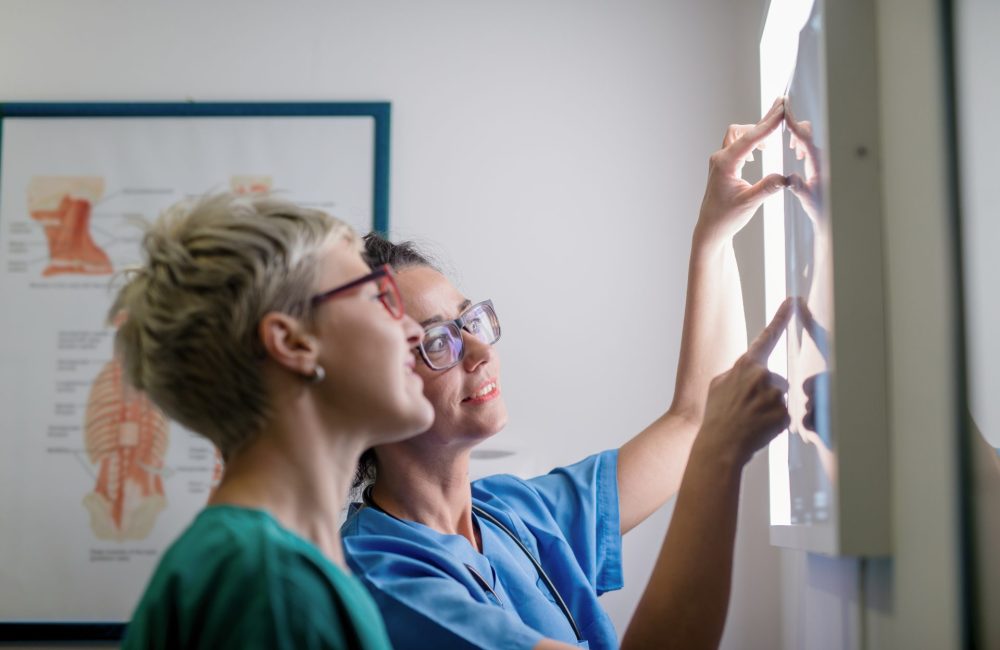 A woman and her doctor review her x-ray for signs of osteoporosis